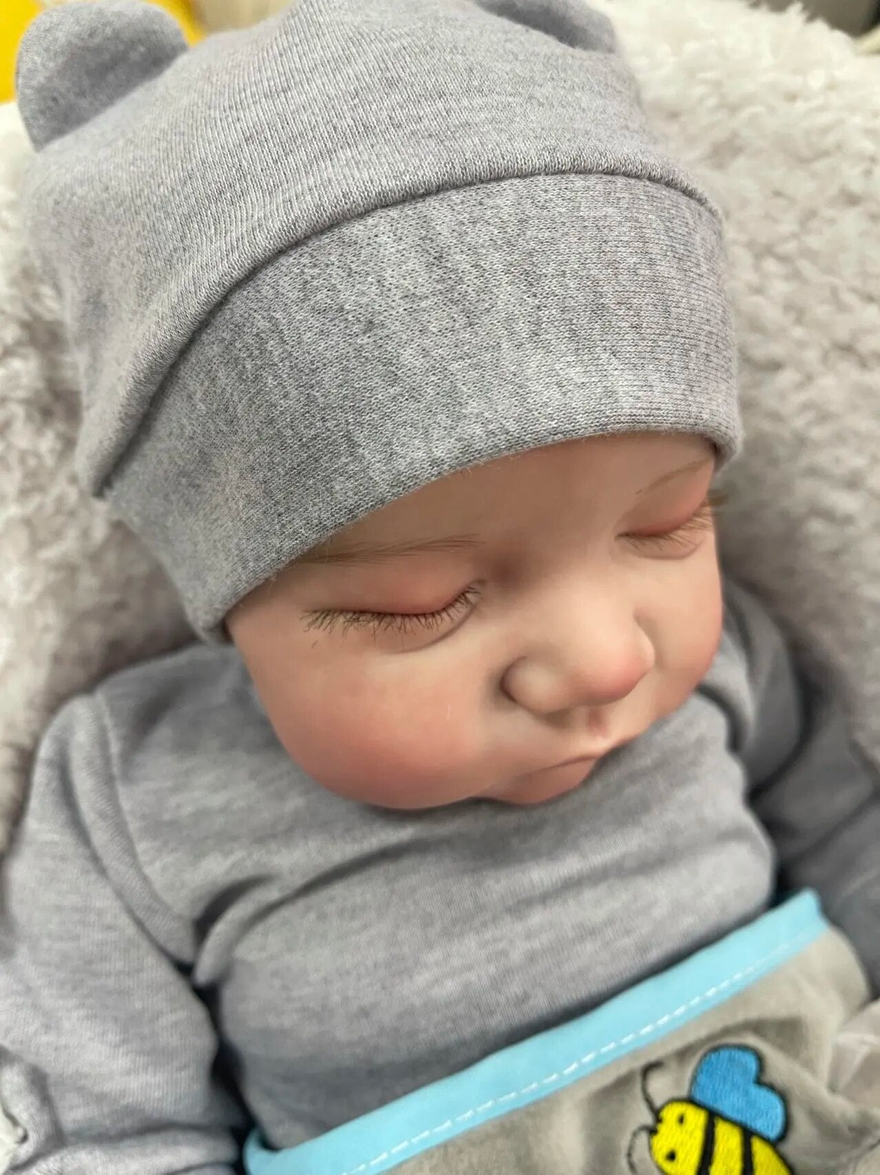 Levi reborn baby doll wearing a bear-ear hat with lifelike vinyl finish, a keepsake gift for girls.
