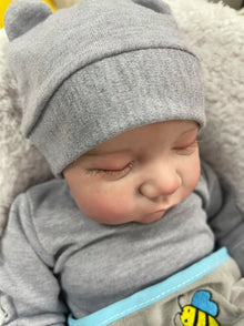 Levi reborn baby doll wearing a bear-ear hat with lifelike vinyl finish, a keepsake gift for girls.