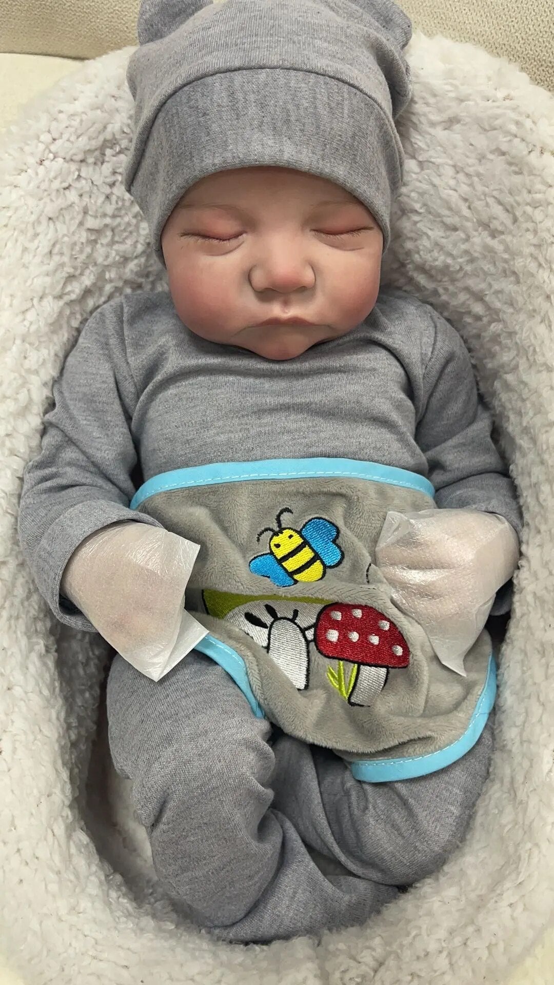 Vinyl Levi reborn baby doll in a cartoon romper with hand-painted hair for realistic pretend parenting play.