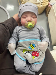 Levi reborn newborn doll with soft vinyl body held in arms for cuddling, role play and photo props.