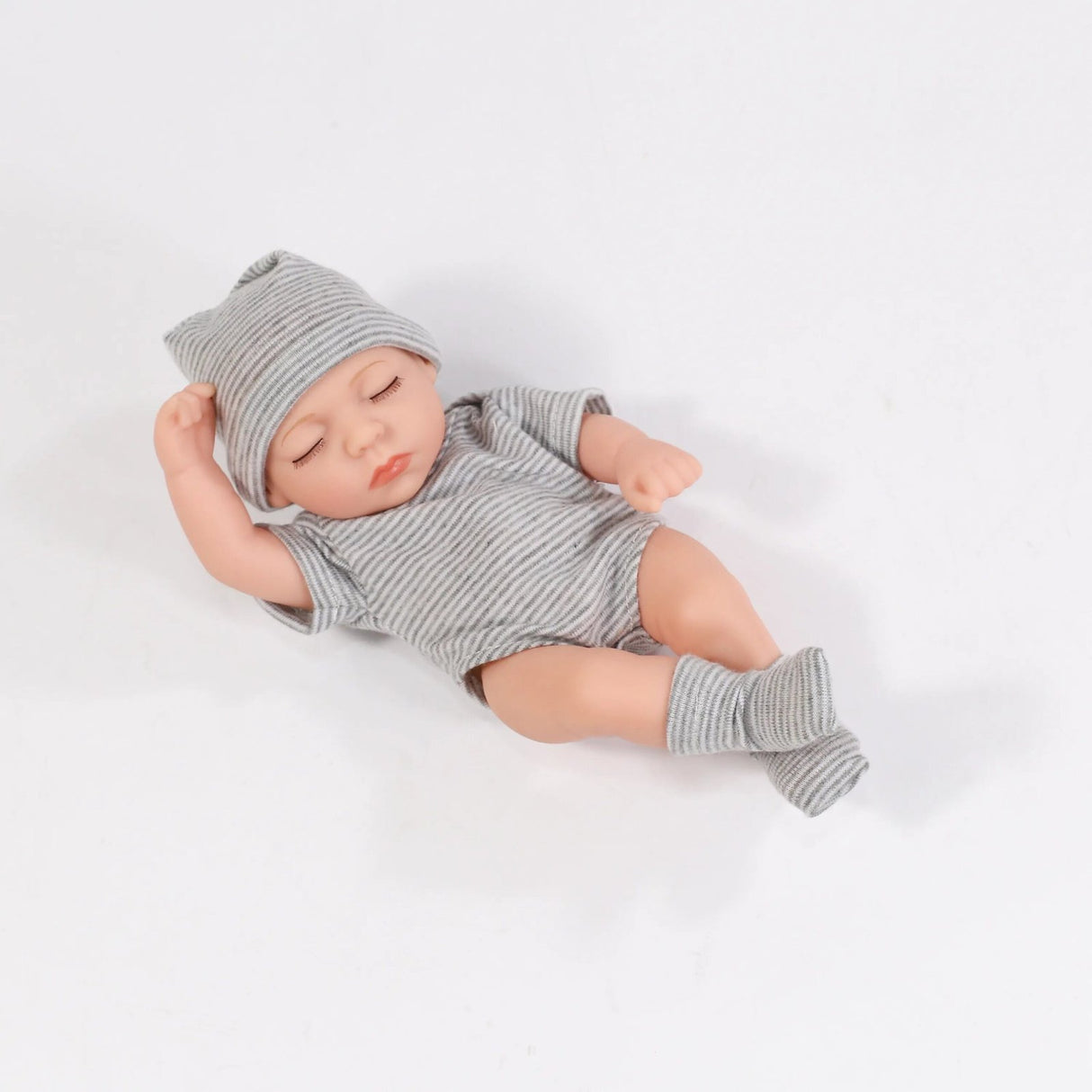 Baby doll wearing a gray striped outfit and hat on a white background