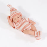 Newborn baby doll wearing a striped outfit and hat on a white background