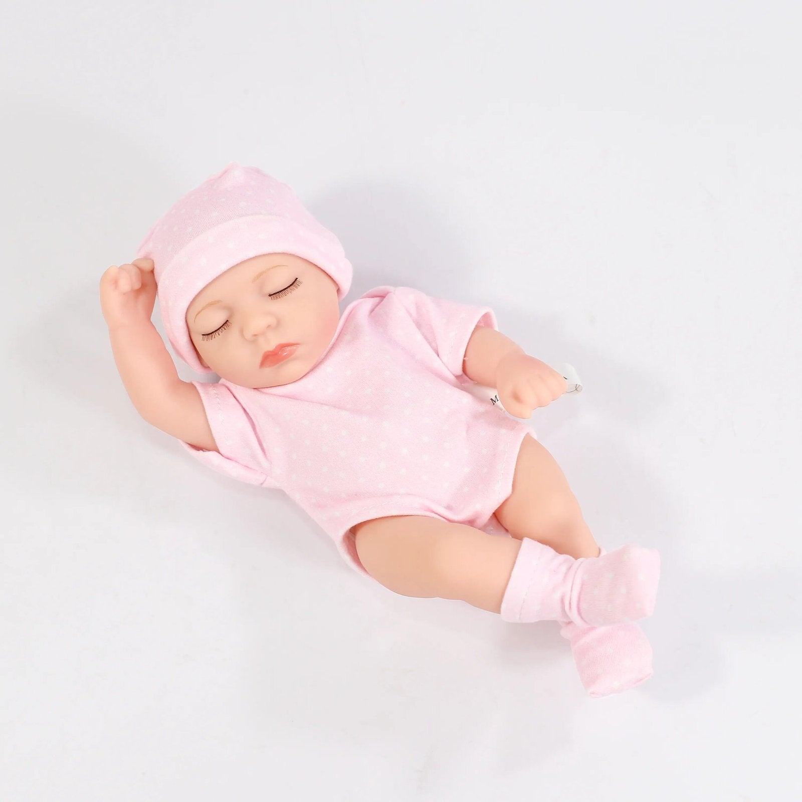 Baby doll in a pink outfit and a hat 