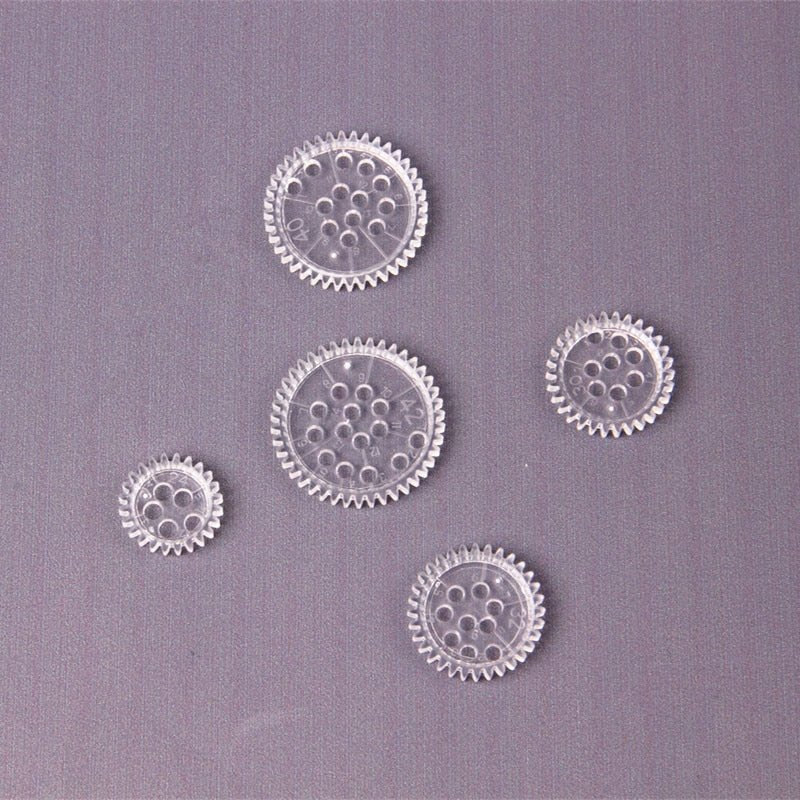 Close-up of five clear drawing gears from the creative kids Spirograph set for precise spiral designs.