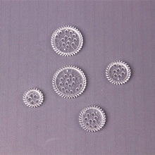 Close-up of five clear drawing gears from the creative kids Spirograph set for precise spiral designs.