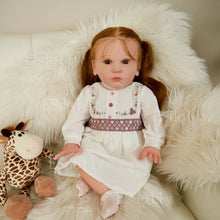 Realistic Mattia reborn baby doll with a giraffe plush for nursery play scenes and gentle cuddle time.