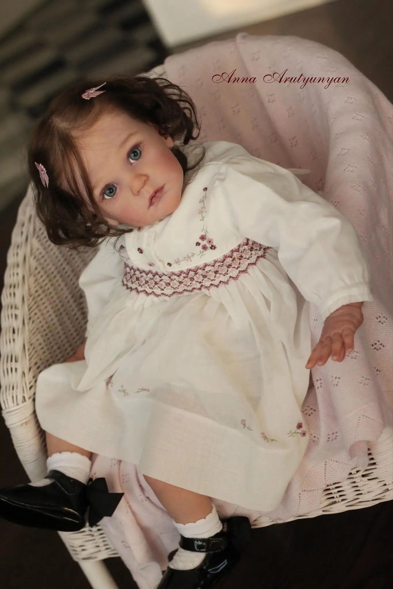 23-inch Mattia reborn doll in a white lace dress with rooted hair for realistic nurturing play and collecting.