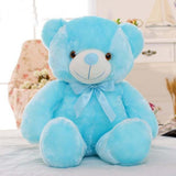 Blue teddy bear with a bow on a light background