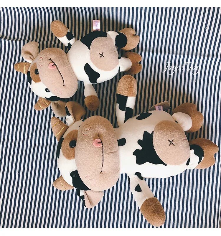 Pair of fluffy cow plush toys as cute farm animal dolls for collecting, playroom decor and gifting.