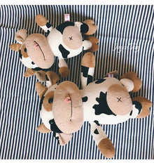 Pair of fluffy cow plush toys as cute farm animal dolls for collecting, playroom decor and gifting.