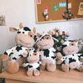 25cm and 35cm milk cow plush toys in four colourways for kids cuddles, nursery decor and gifting.