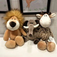 Three plush toys resembling a lion, elephant, and giraffe on a tiled floor.