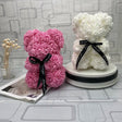 Pink and white rose bears with black ribbons on a patterned surface