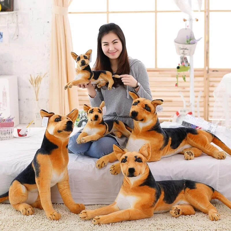 Woman holding a small dog plush toy with large dog plush toys on a bed.