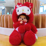 Red plush toy with a white face and black eyes, sitting on a wooden surface.