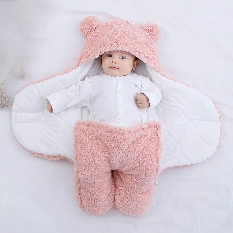 Baby in a pink and white outfit with bear ears on a light gray background