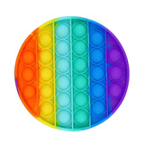 Round rainbow-colored pop-it fidget toy on a white background