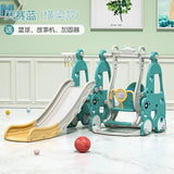 Children's playground equipment with slide and swing set on a light wooden floor.