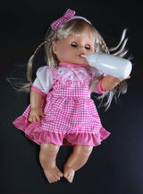 Doll in a pink dress holding a bottle.