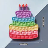 Colorful pop-it toy shaped like a birthday cake with candles on a light blue background