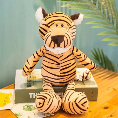 Plush tiger toy on a wooden surface with a green leafy background