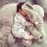 Baby sleeping on a large gray elephant-shaped pillow.