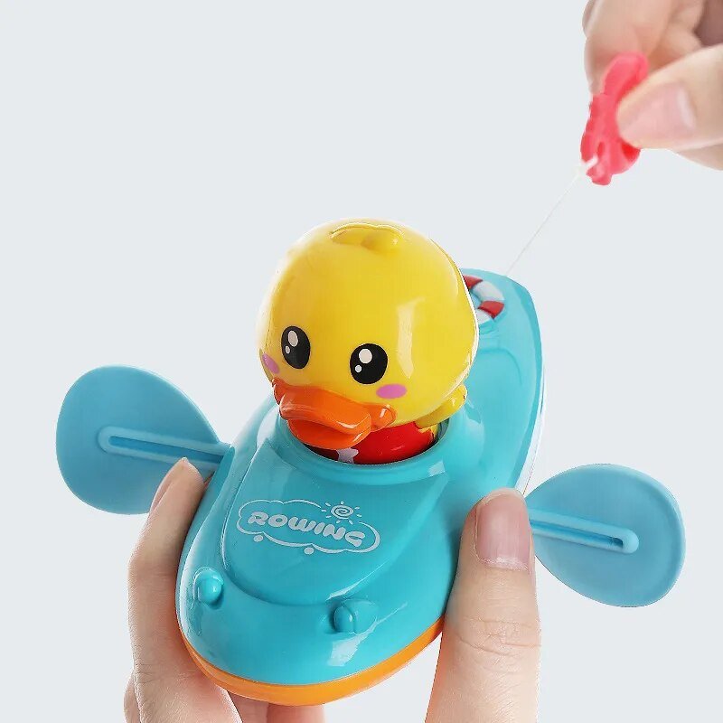 Toy duck with a blue base held by a hand on a white background