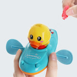 Toy duck with a blue base held by a hand on a white background