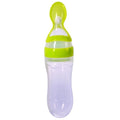 Green baby feeding bottle with spoon on a white background