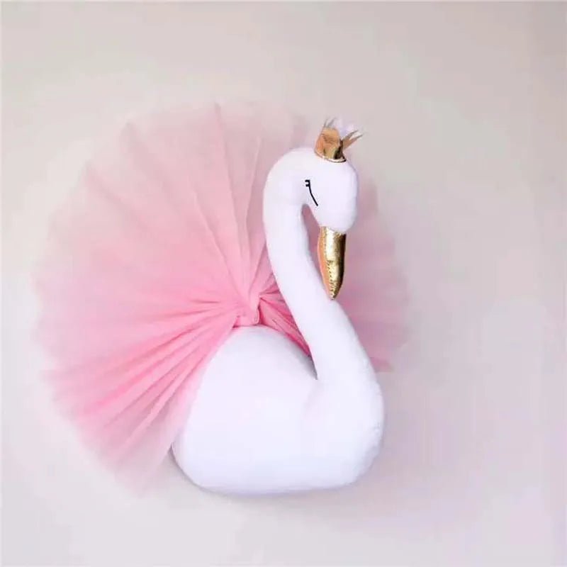 Plush toy swan with a pink tutu and gold crown on a light gray background