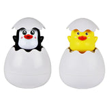 Two small animal figures, a penguin and a duck, inside eggshells on a white background.