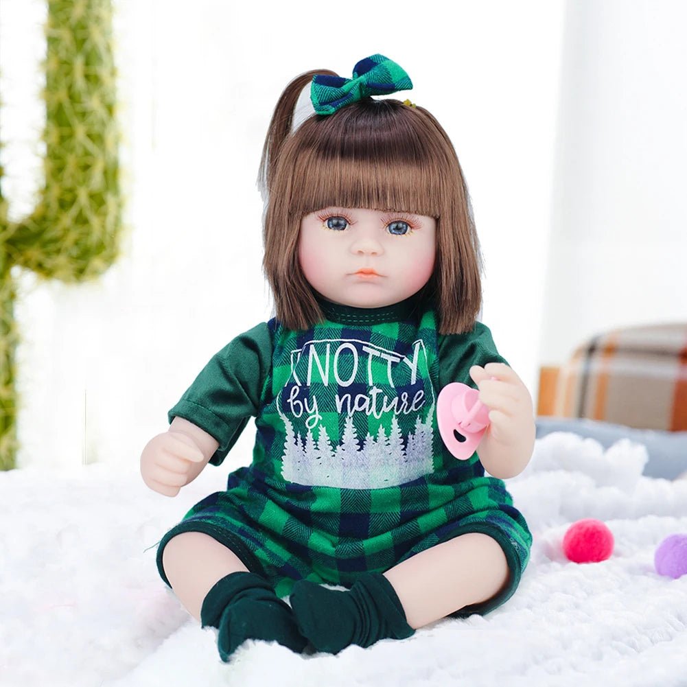  Doll in a green outfit with text sitting on a white surface.