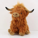 Plush toy of a brown Highland cow on a white background