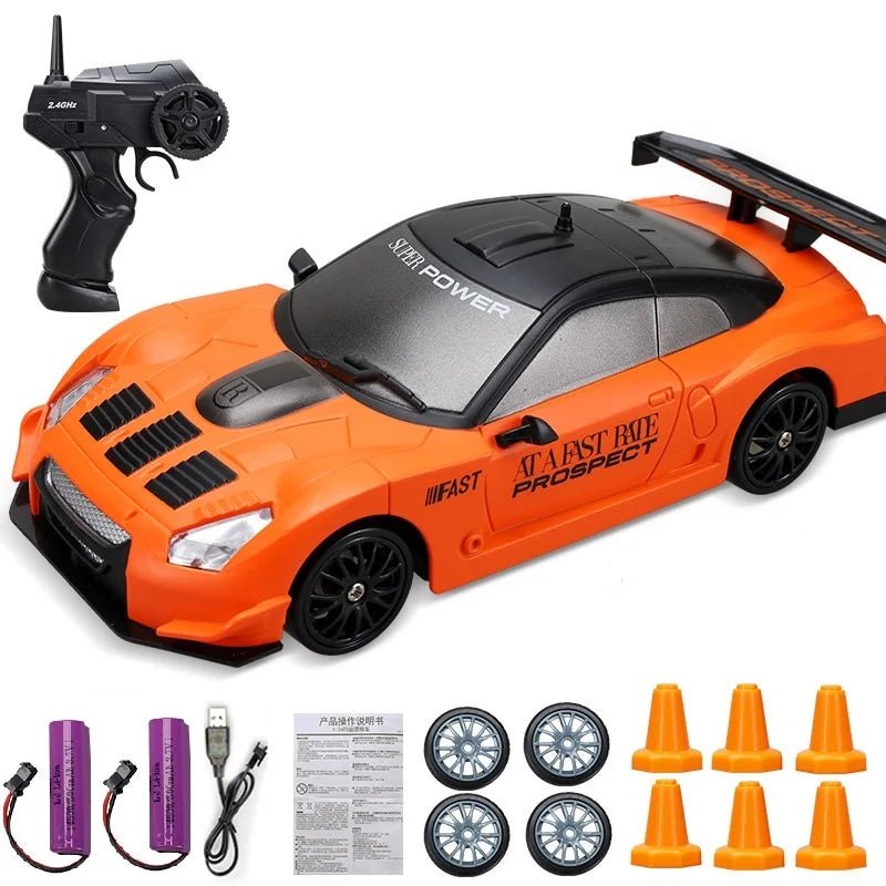 Orange toy car with remote control, wheels, and cones