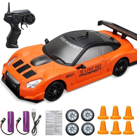 Orange toy car with remote control, wheels, and cones