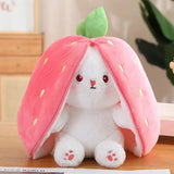 Plush toy shaped like a strawberry with a white bunny inside on a wooden surface.