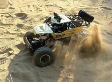 4WD RC electric truck driving across sand, an off-road toy built for beach outings and holiday play.