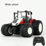 Toy tractor with wide wheels and a remote control on a white background