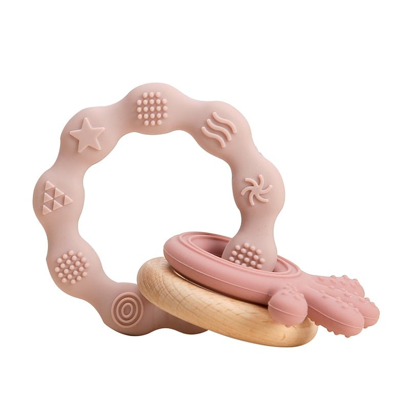 Pink and wooden teething ring on a white background