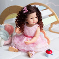 55CM Full Body Silicone Reborn Toddler fashion doll with curly hair and pink dress for soft touch cuddling, collecting, and gifting.
