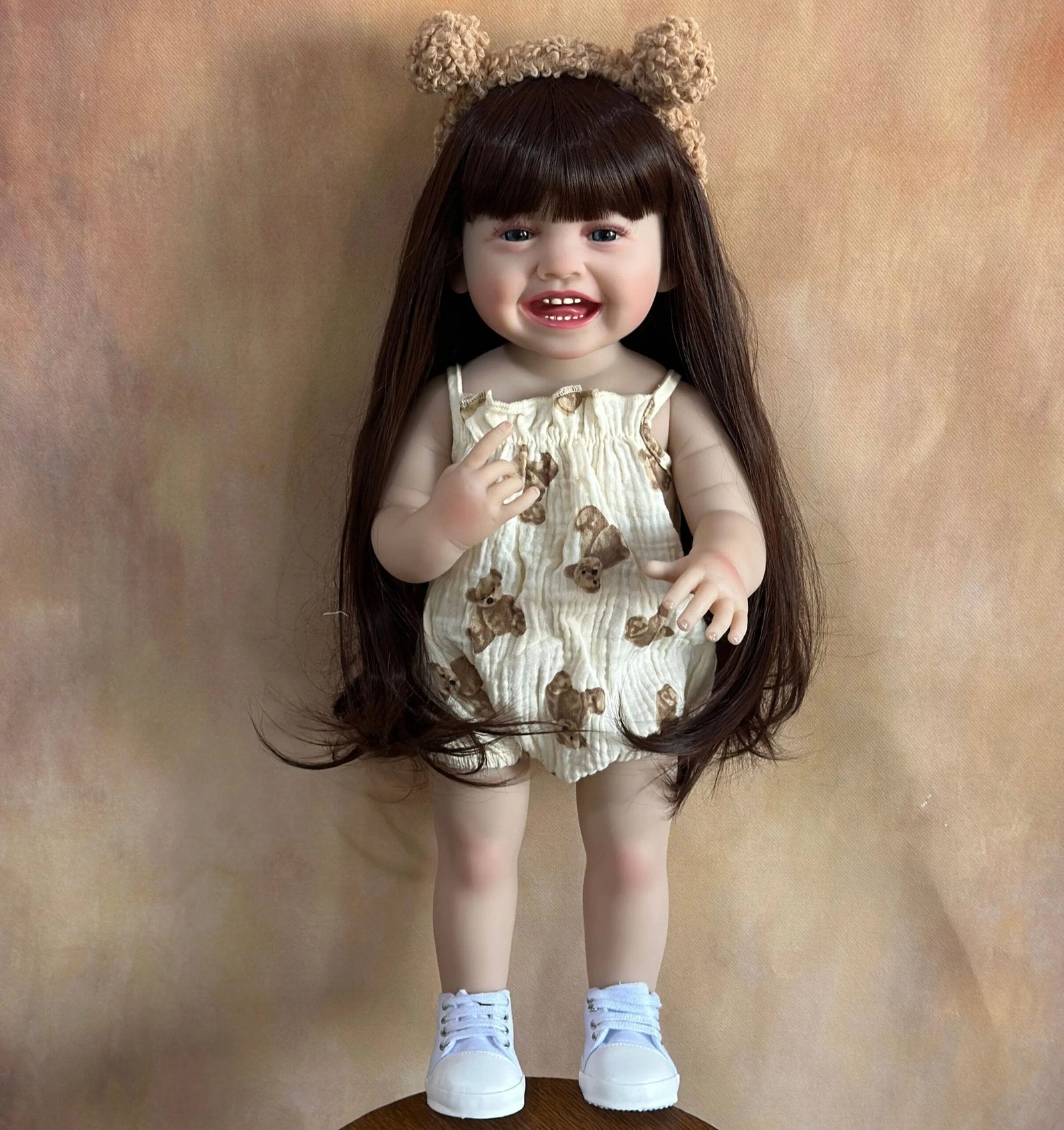 Standing Reborn Doll in a bear-themed outfit with headband, a lifelike silicone baby doll for dress-up play and gifting.