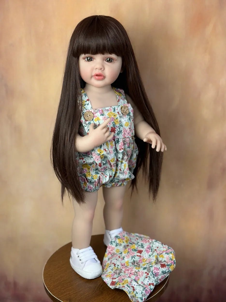 Standing Reborn Doll in a floral set with brown hair showing realistic face detail, a soft silicone doll for collecting and play.