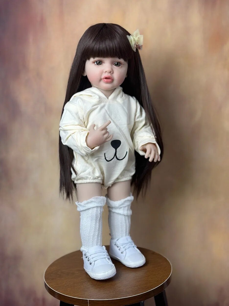 Close-up of the Standing Reborn Doll in a white printed outfit showing rooted hair detail, a realistic silicone doll for gifting.