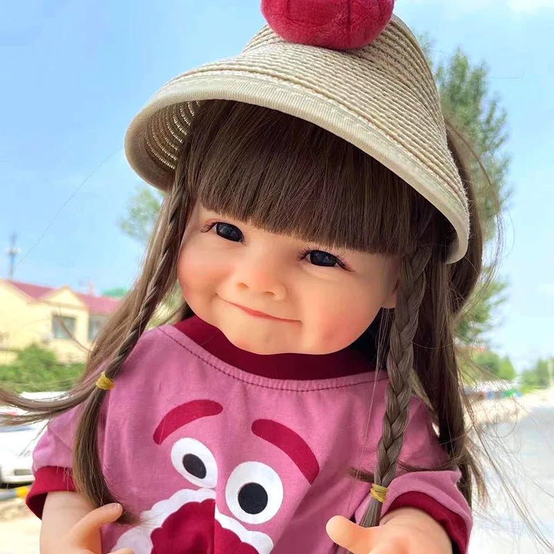 Waterproof Reborn Doll in a straw hat and pink outfit outdoors, a curly hair silicone baby doll for stroller walks and park play.