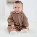 Baby wearing a brown fuzzy outfit on a white background