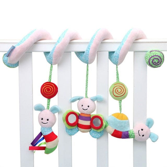 Colorful baby crib mobile with caterpillar design hanging on a white crib.