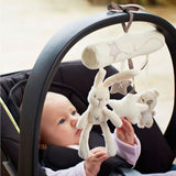 Baby in a car seat with a plush toy mobile above