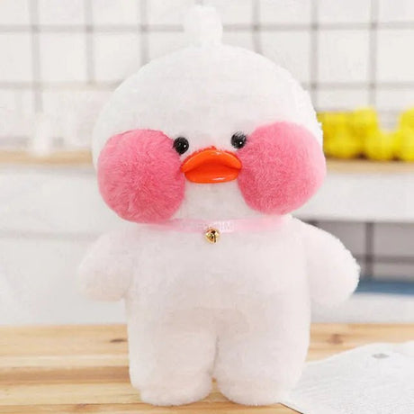 Plush toy duck with pink cheeks and an orange beak on a wooden surface.