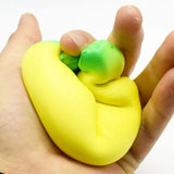 Hand holding a yellow and green squishy toy against a white background