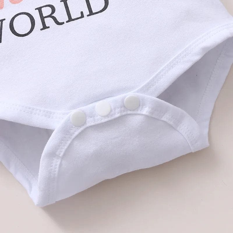 Close-up of a baby onesie with 'WORLD' text on a light background